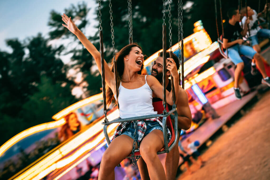 Young couple enjoying being on the swings