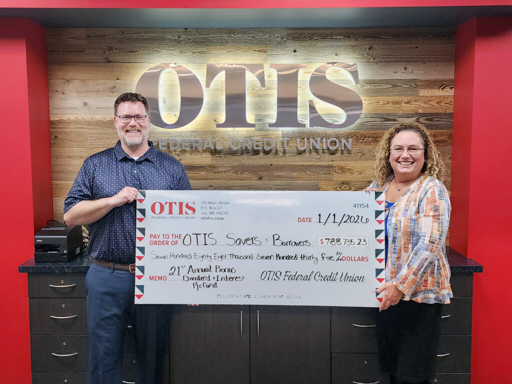 man and woman holding large check made out to OTIS Savers and Borrowers